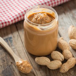 Creamy,And,Smooth,Peanut,Butter,In,Jar,On,Wood,Table. Creamy,And,Smooth,Peanut,Butter,In,Jar,On,Wood,Table.